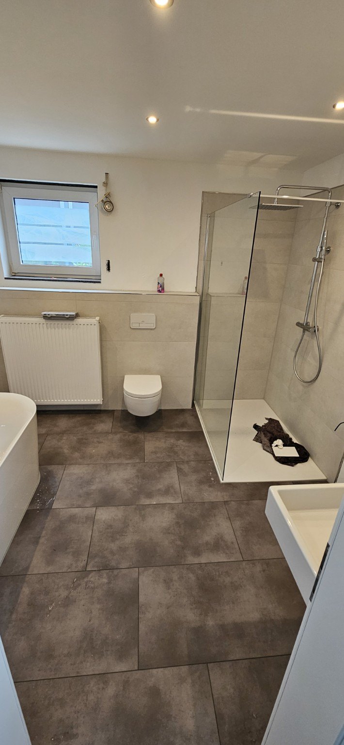 Bad mit Badewanne, bodengleicher Dusche und großformatigem Boden